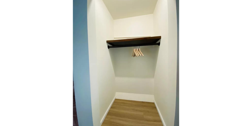 an empty closet space with no doors, a shelf and hanger rack