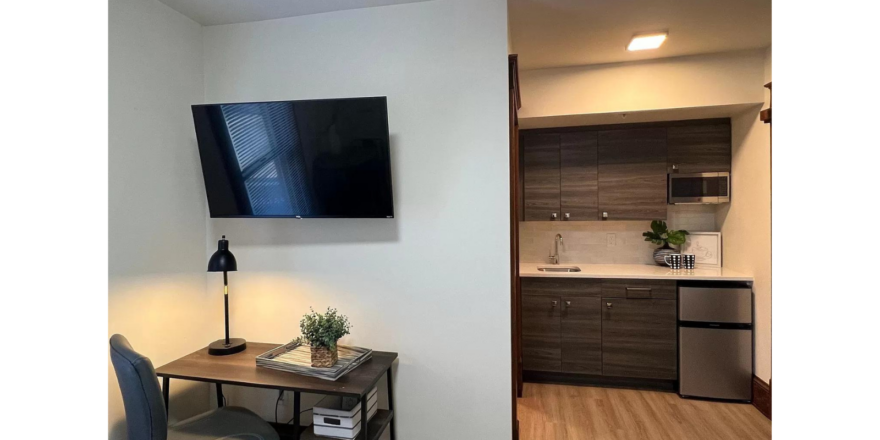 a flat screen tv mounted to the wall above a desk
