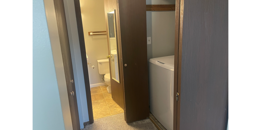 a bathroom ahead and laundry closet to the right of the bathroom entry