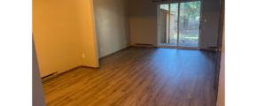 an empty living room with hard wood floors and sliding glass doors