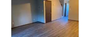an empty living room with hard wood floors