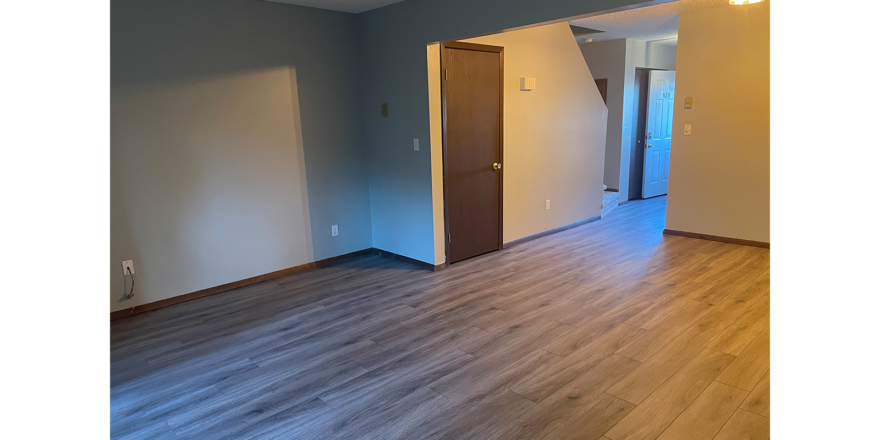 an empty living room with hard wood floors