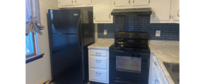 a kitchen with black appliances and white cabinets