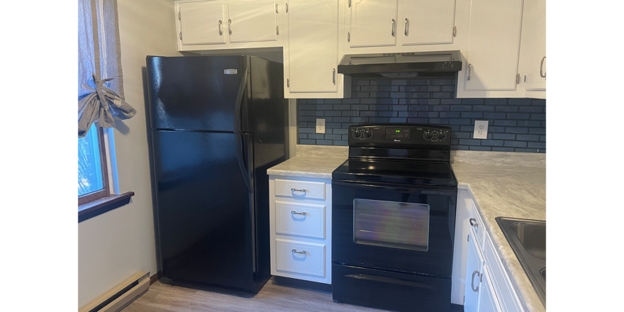 a kitchen with black appliances and white cabinets