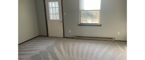 an empty bedroom with a window and a door leading to a balcony/deck