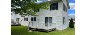 white duplex with black shutters and two decks