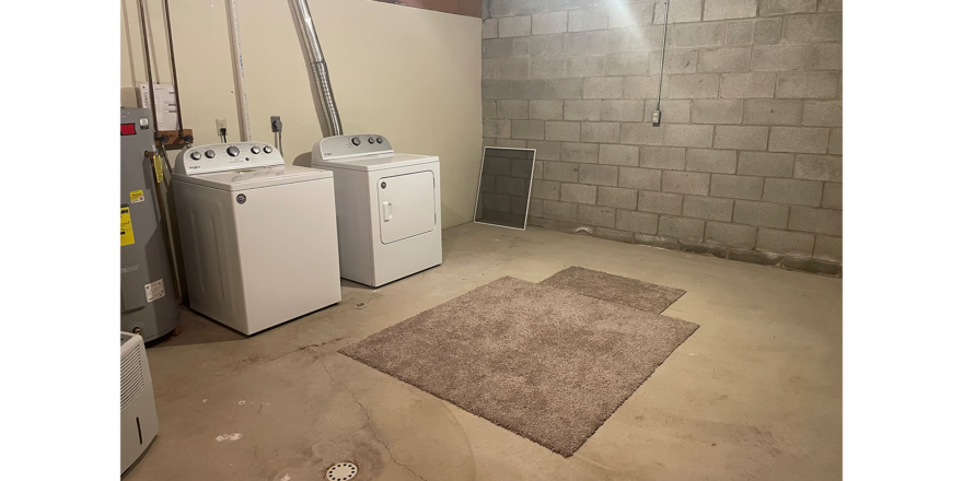 three washers and a dryer in a room