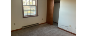 an empty room with a window and a radiator