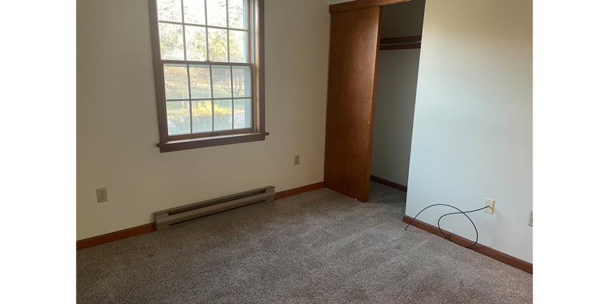 an empty room with a window and a radiator