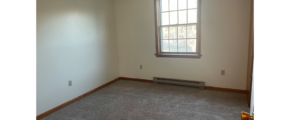 an empty room with carpet and a window