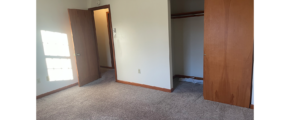 an empty room with two doors and carpet