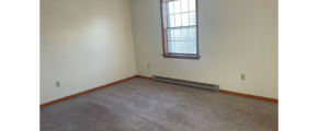 an empty room with carpet and a window