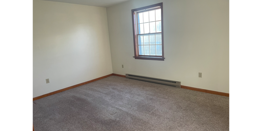 an empty room with carpet and a window