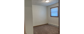 an empty room with carpet and a window
