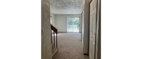 a hallway leading to a door and a window