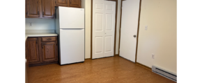 an empty kitchen with a refrigerator and a stove