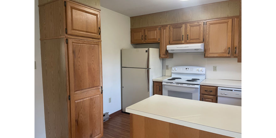 a kitchen with white appliances and wooden cabinets