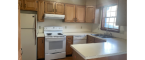 a kitchen with white appliances and wooden cabinets