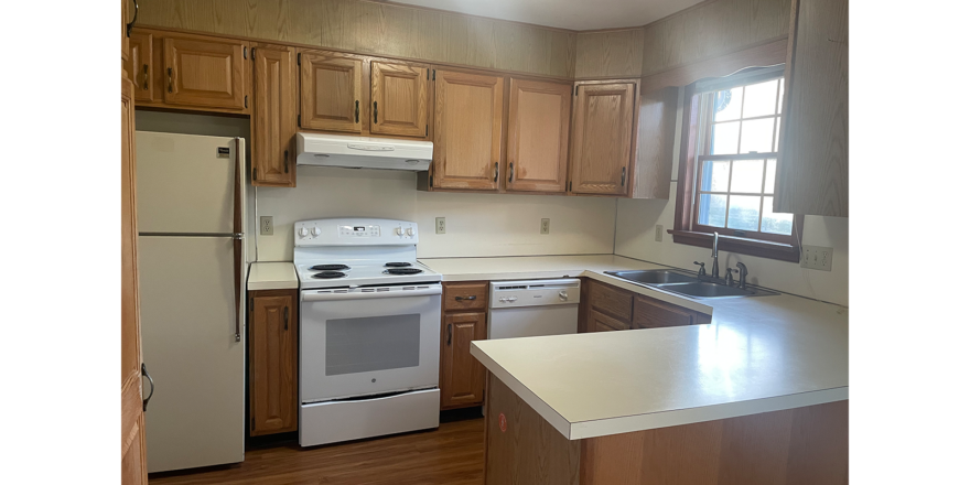 a kitchen with white appliances and wooden cabinets