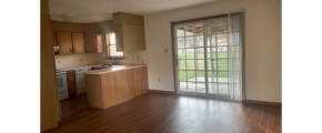 an empty kitchen and living room with wood floors