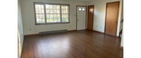 an empty living room with wood floors and windows