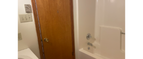 a white bath tub sitting next to a wooden door