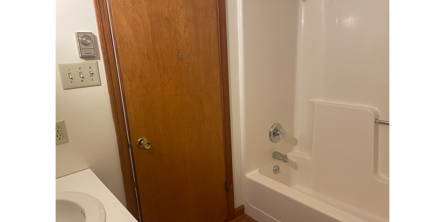 a white bath tub sitting next to a wooden door
