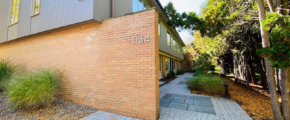 a brick and gray sided building with a walkway leading to it