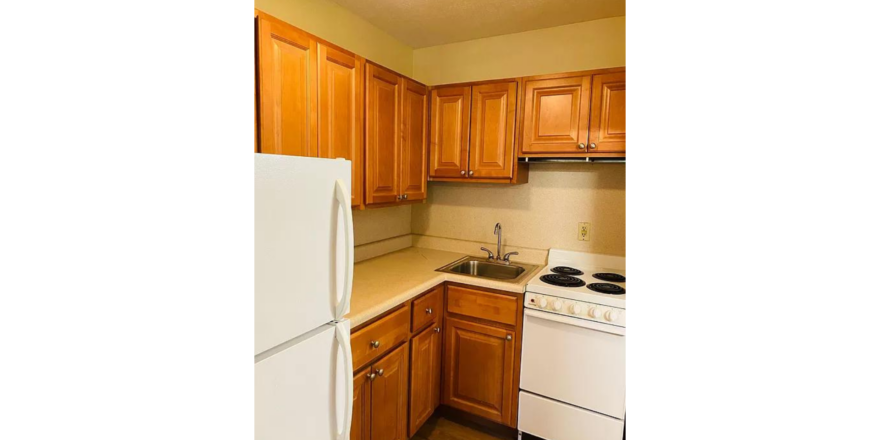 a kitchen with wooden cabinets and white appliances