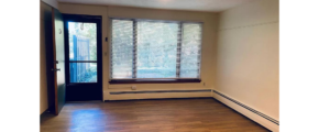 an empty room with wood floors and a ceiling fan