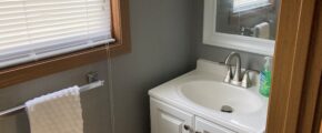 a bathroom with a sink, mirror and towel rack