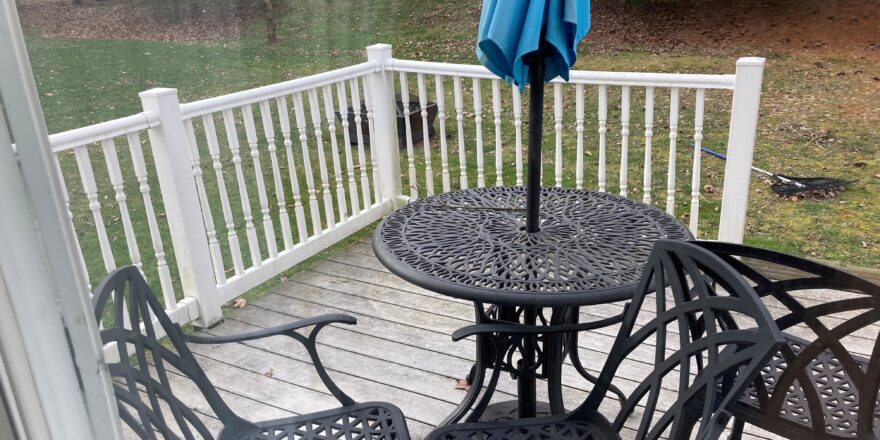 an umbrella is set up on the back porch