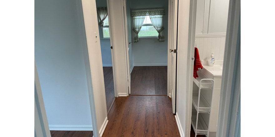 a hallway leading to a bathroom and bedrooms