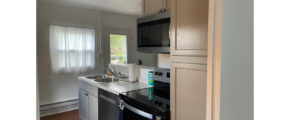 marble counter top, sink, stainless steel microwave, dishwasher, and oven, in a kitchen with brown LVP flooring