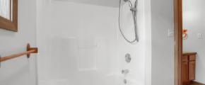 a bathroom with a bathtub, sink, and mirror