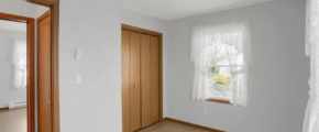 an empty room with wood floors and white walls