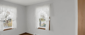a empty room with two windows and a radiator