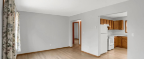 an empty living room with wood floors and white walls