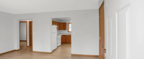 an empty living room with wood floors and white walls