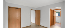an empty room with wooden doors and a hard wood floor