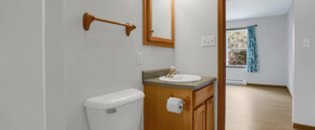 a bathroom with a toilet, sink and mirror