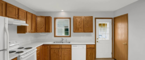 a kitchen with white appliances and wooden cabinets