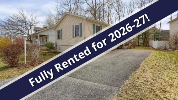 a house for sale with a blue ribbon in front of it