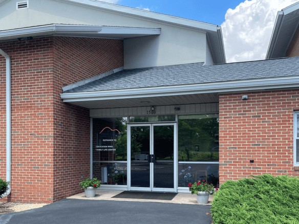 brick building with glass windows and a parking lot in front of it