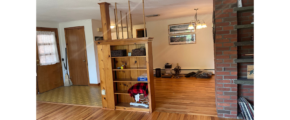 a living room with wood floors and a brick fireplace