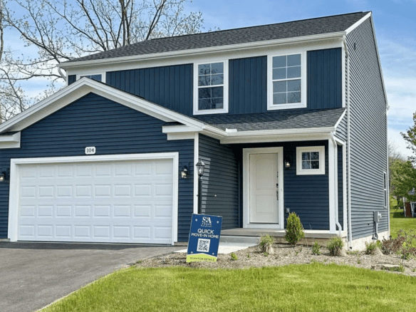 a two story house with blue siding and a white garage