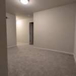 an empty room with carpet and a door