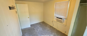 an empty room with a window and a radiator