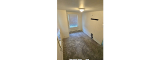 an empty room with wood floors and a window