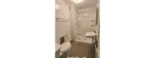 a bathroom with a toilet, sink, and shower